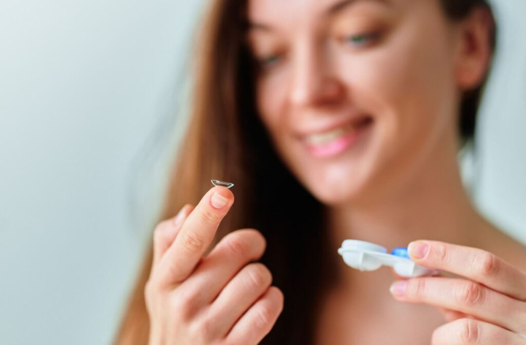 a woman is placing her dry-eye safe contact lenses in her eyes.