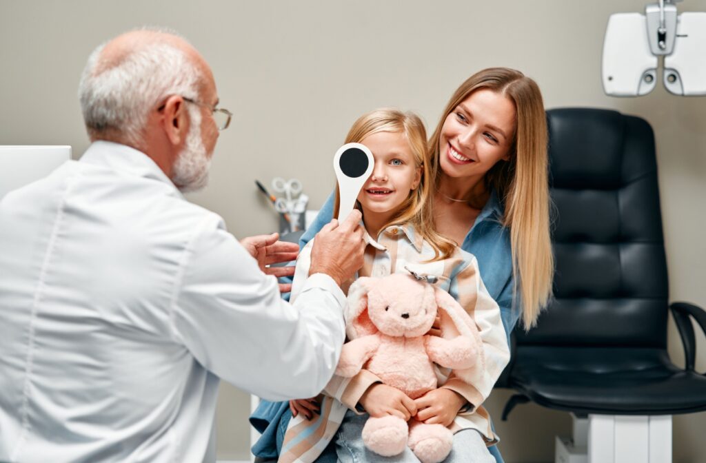 An optometrist assesses a young child's visual acuity during their routine eye exam.