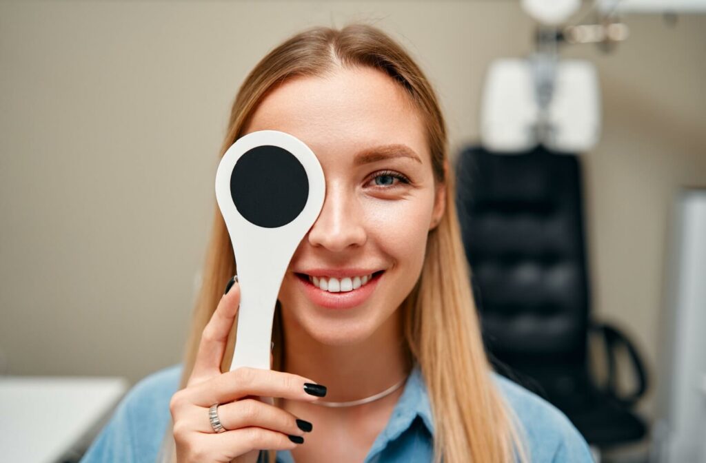 a person holding an eye cover as part of their personalized eye exam.